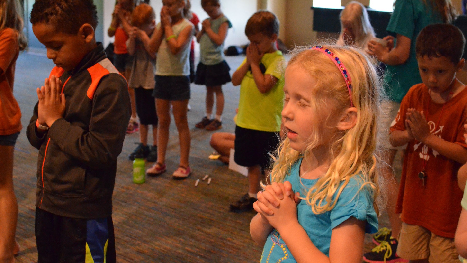 A group of kids praying at Brookwood Church